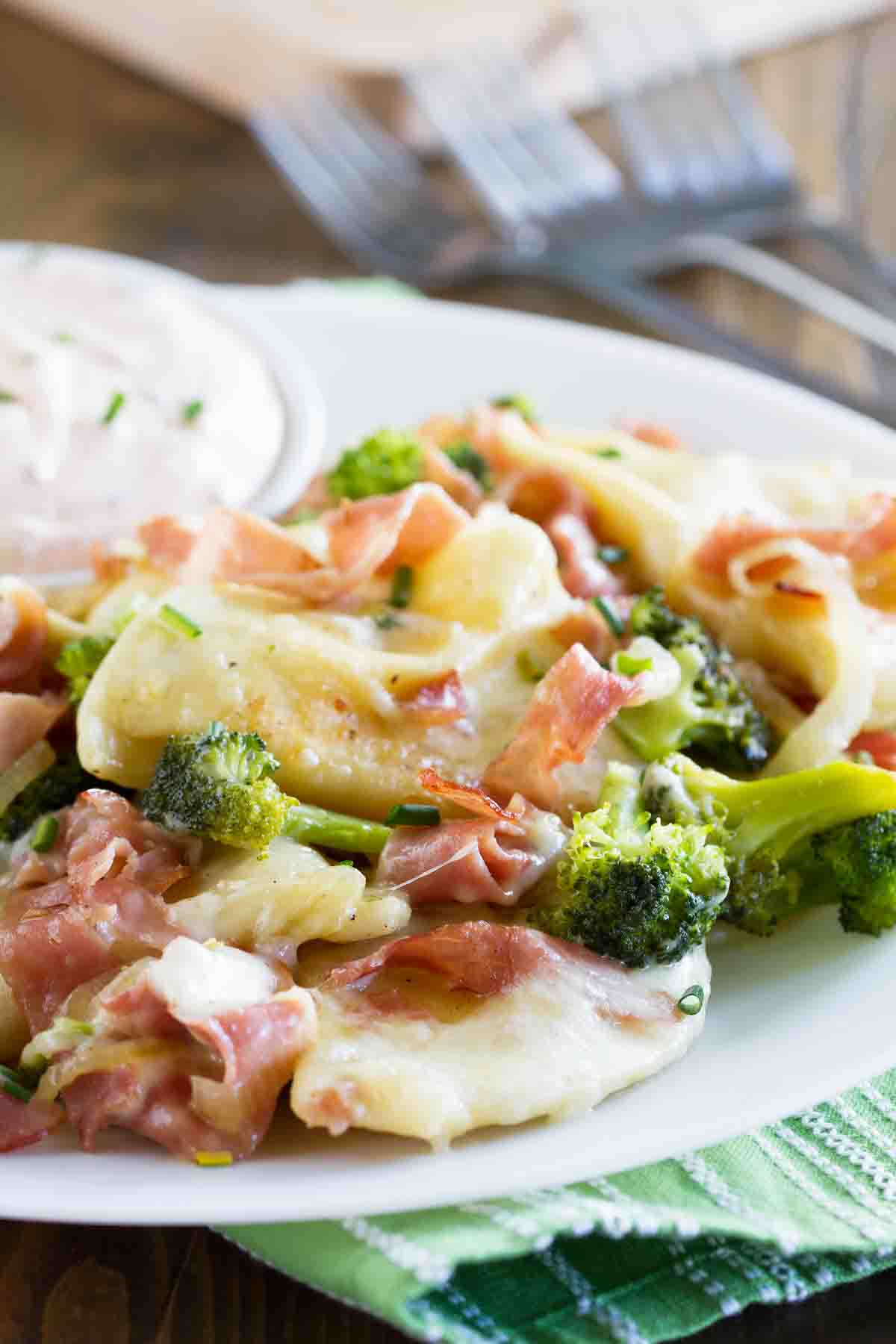 Starting with frozen pierogi makes these Pierogies with Ham and Broccoli an easy weeknight meal. It’s a fun and tasty meal that the whole family will love! Pierogi recipe with ham and broccoli served with dipping sauce.