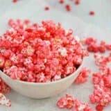 bowl filled with Red Hot Popcorn with red hot candies around