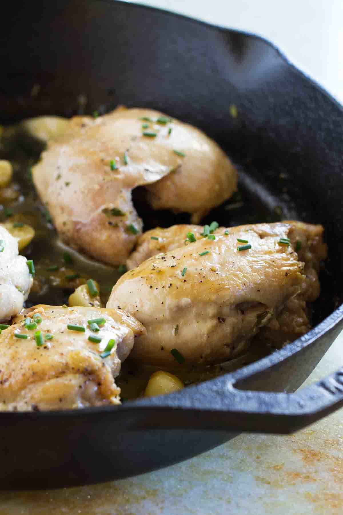 Finished in 30 minutes, this easy Skillet Chicken with Garlic and Herbs has tons of flavor with very little effort. And the cleanup is easy, too! Skillet Chicken with Garlic and Herbs in a cast iron skillet.