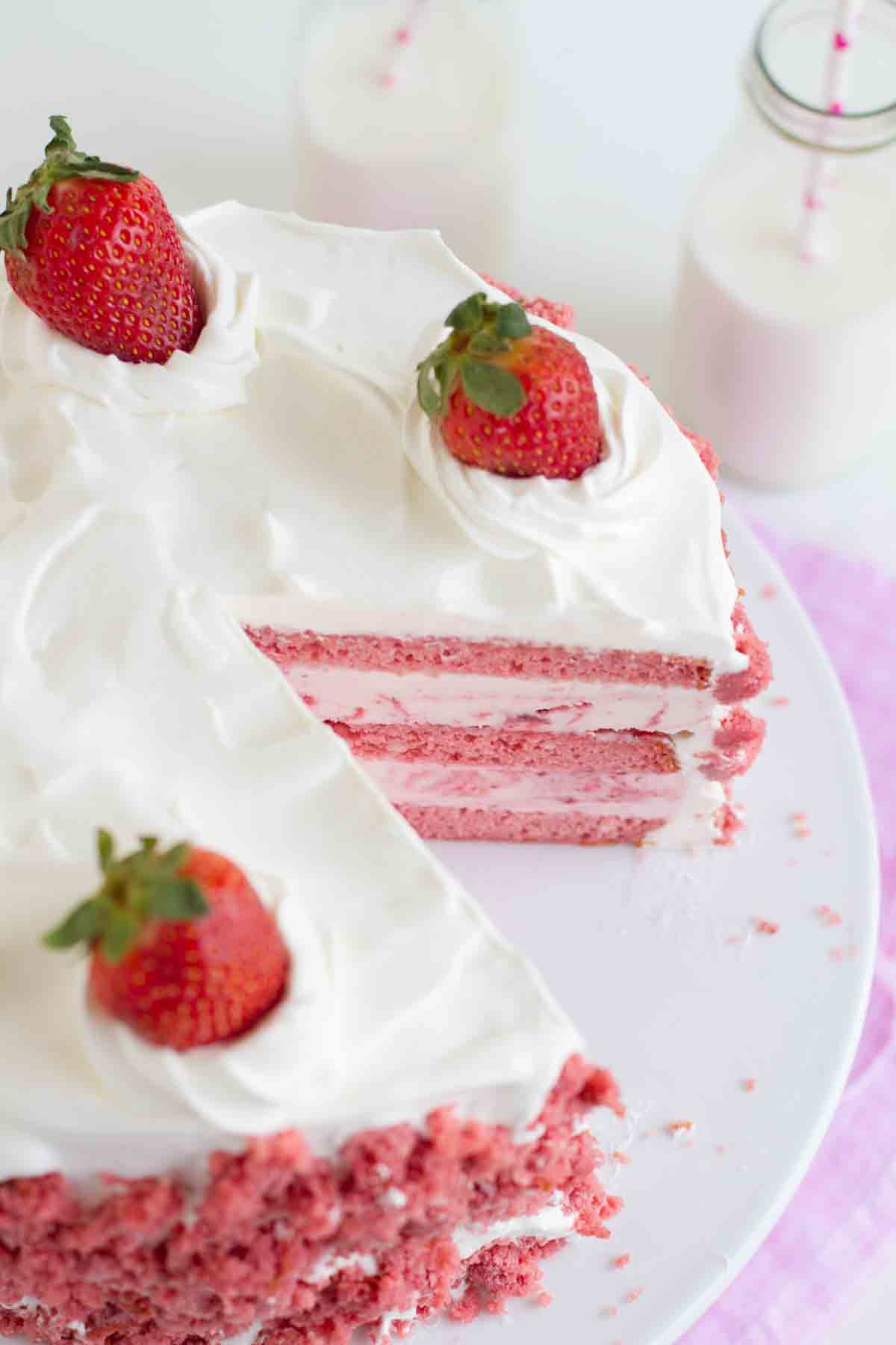 Strawberry Milkshake Ice Cream Cake with a slice taken out of it.