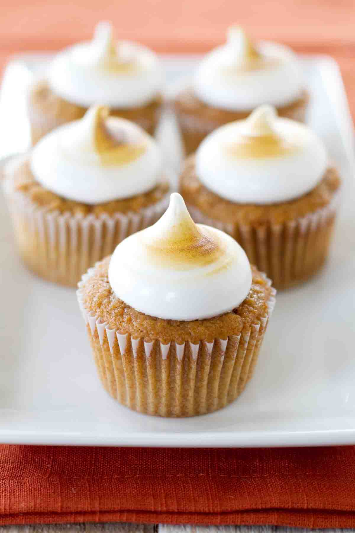 A plate full of Sweet Potato Cupcakes that are topped with toasted marshmallow frosting.