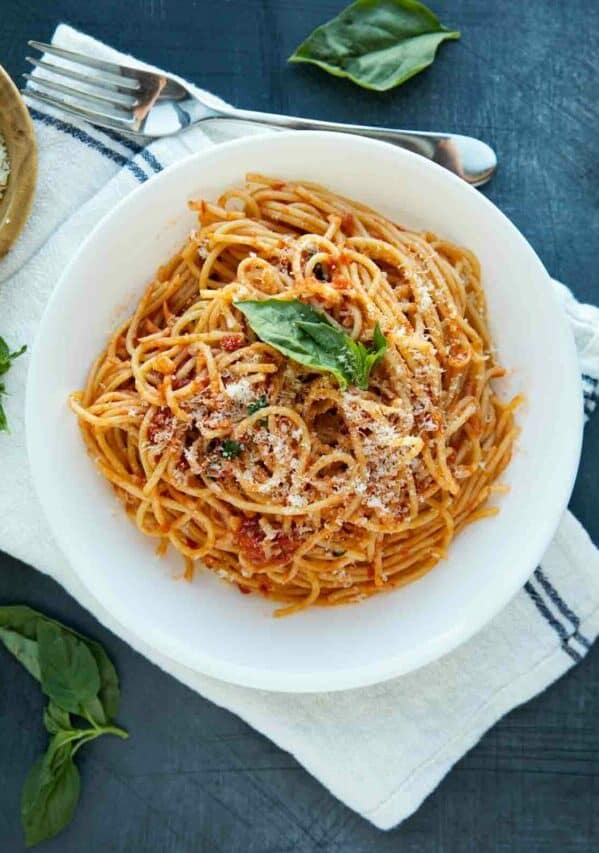 garlic spaghetti topped with parmesan and fresh basil