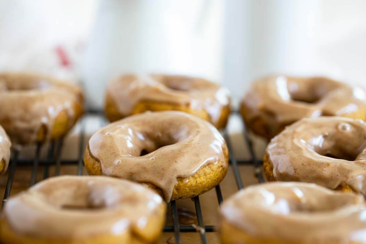 Baked Pumpkin Donuts with Maple Cinnamon Glaze on a cooling rack.