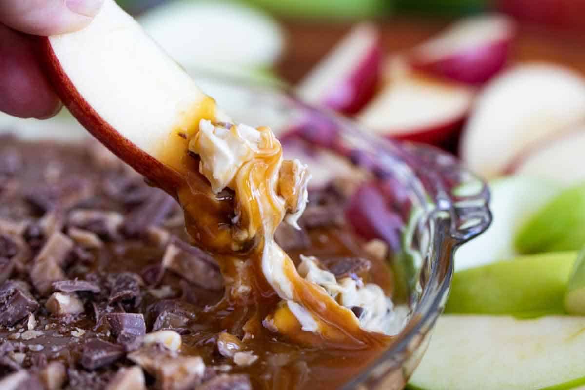 Dipping an apple slice into caramel apple dip.