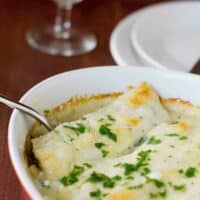 Baking dish with Chicken Manicotti with Mushrooms topped with parsley.