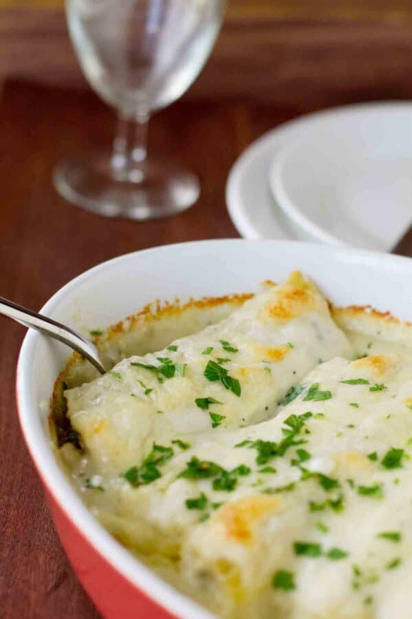 Baking dish with Chicken Manicotti with Mushrooms topped with parsley.