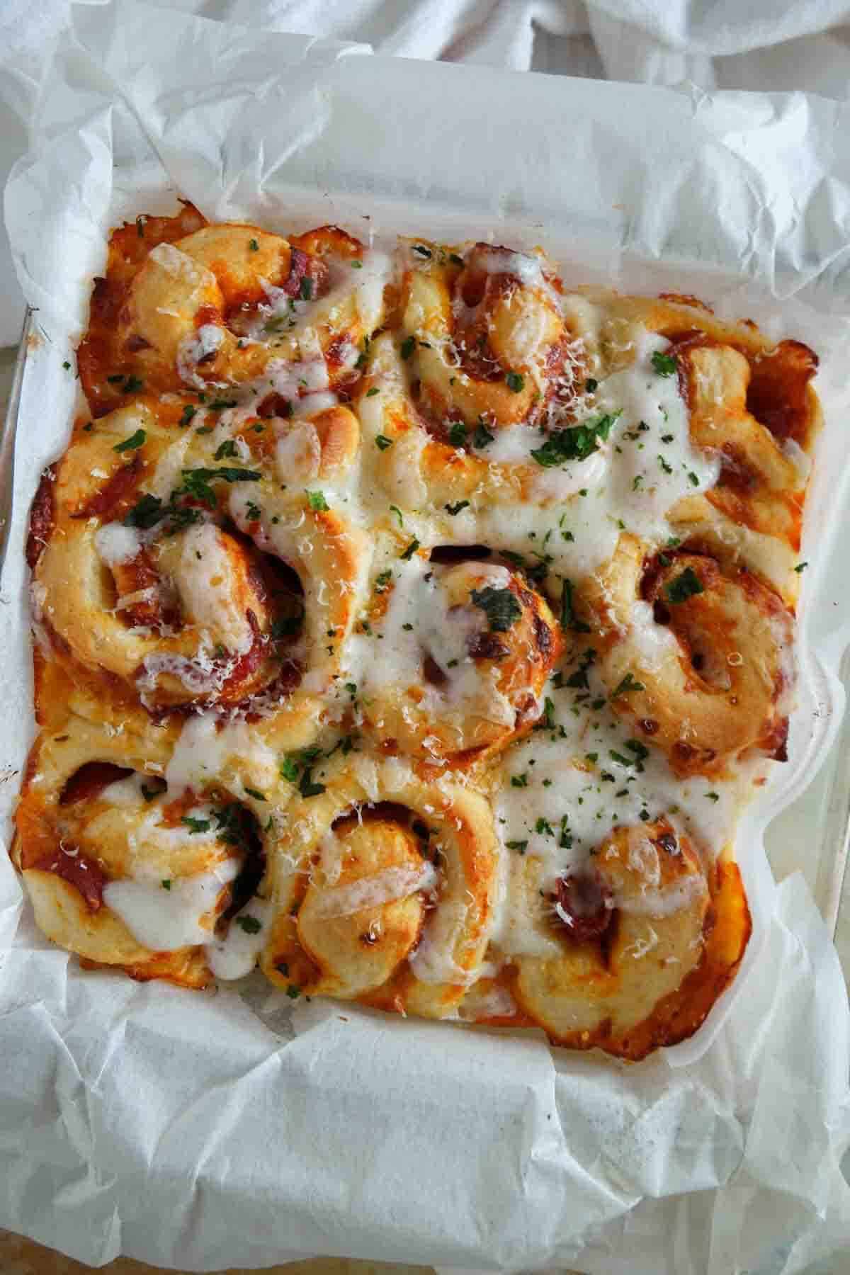 Pizza rolls baked in a dish with cheese and pepperoni.