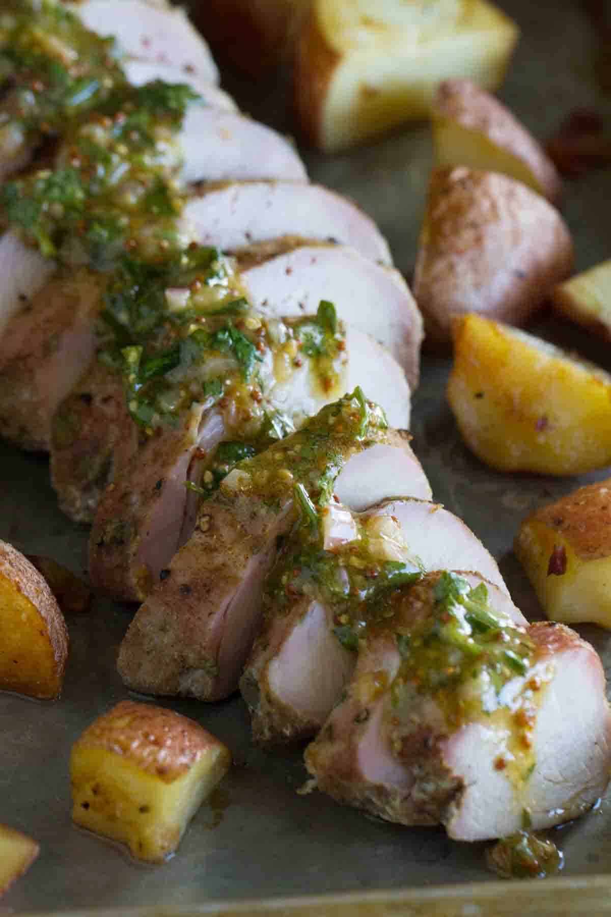 Sliced roasted pork tenderloin topped with mustard sauce and served with potatoes.
