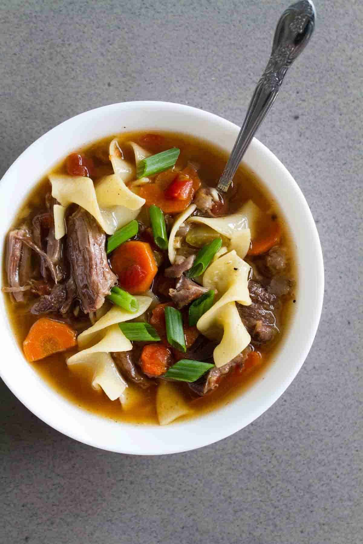 Super tender and slow cooked, this Slow Cooker Beef Noodle Soup is the definition of comfort food! Put it in the slow cooker in the morning, and a flavorful noodle soup is ready for dinner! Slow Cooker Beef Noodle Soup with vegetables.