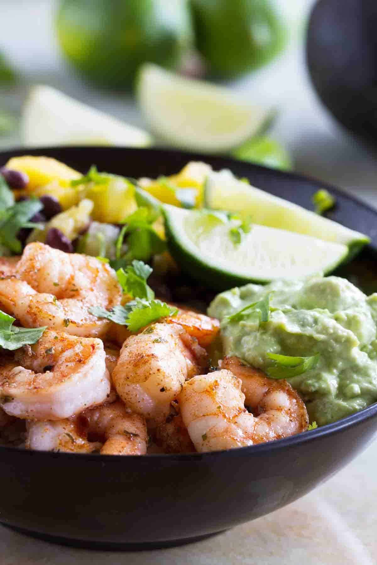 Spicy Shrimp Bowl with avocado and lime slices.