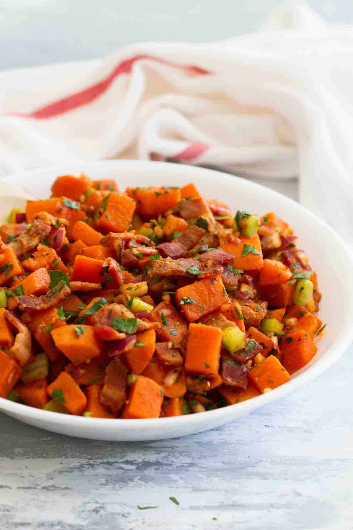 Sweet potato salad with bacon and herbs in a bowl.