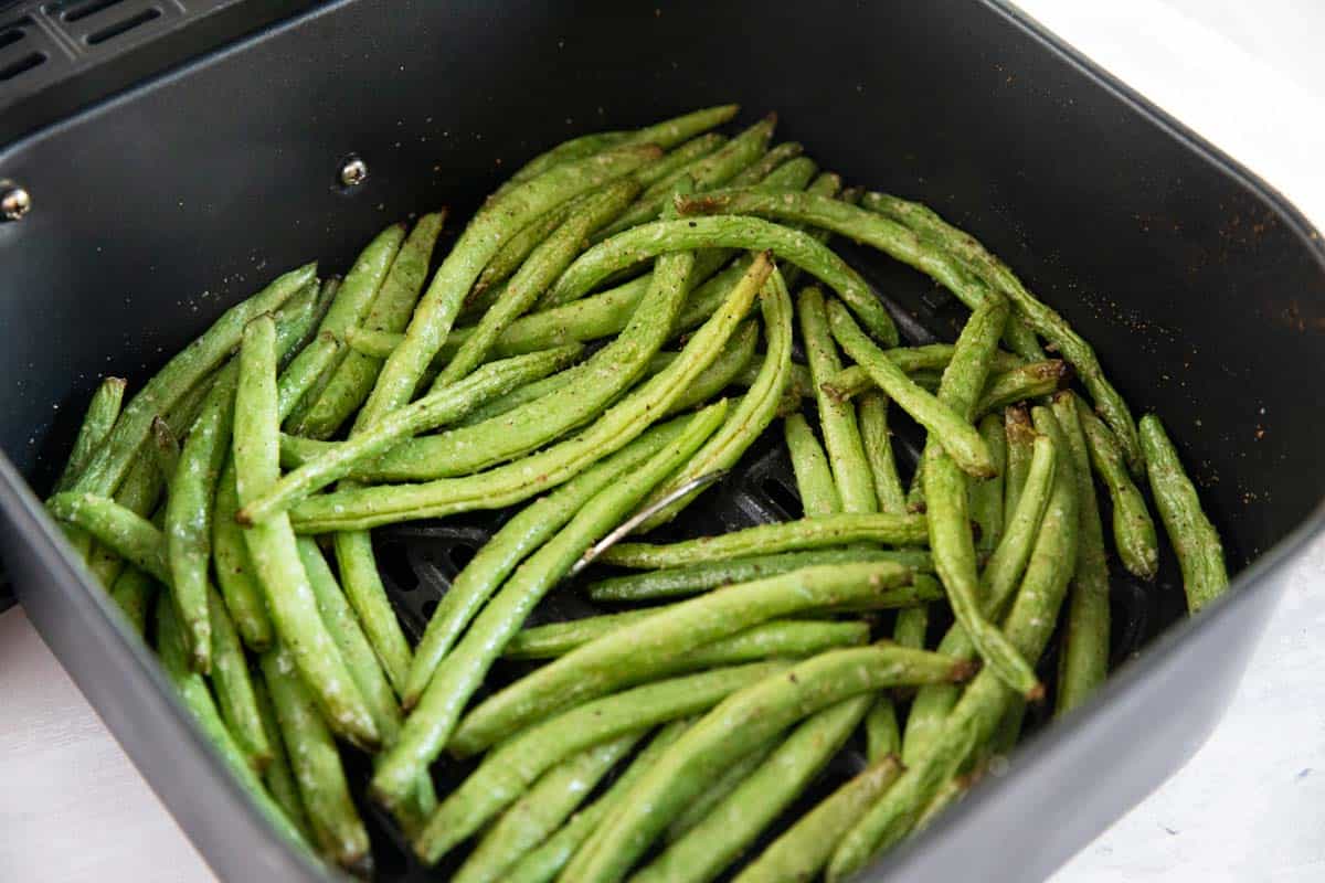 Green beans in an air fryer basket.