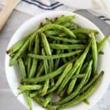 Bowl of green beans cooked in the air fryer in a bowl.