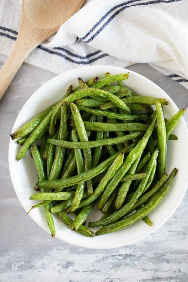 Bowl of green beans cooked in the air fryer in a bowl.