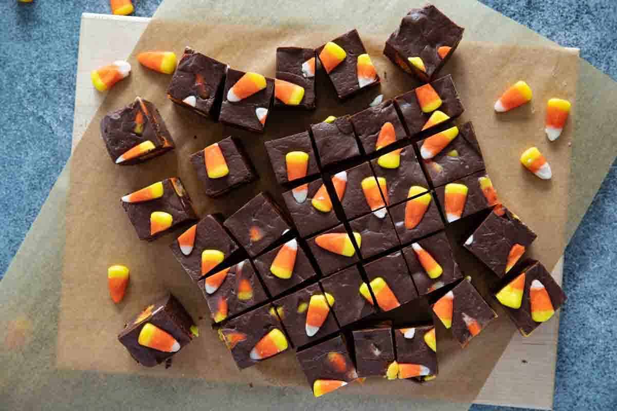 Candy corn fudge on parchment paper that has been sliced into squares.