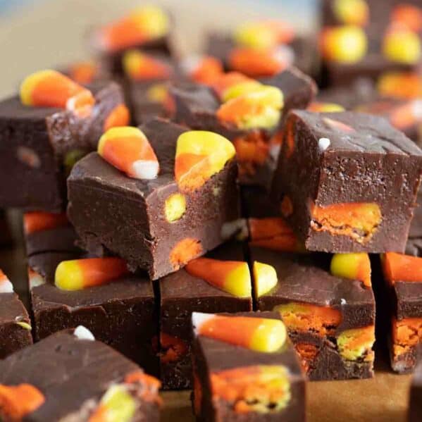 Pieces of candy corn fudge stacked on top of each other.