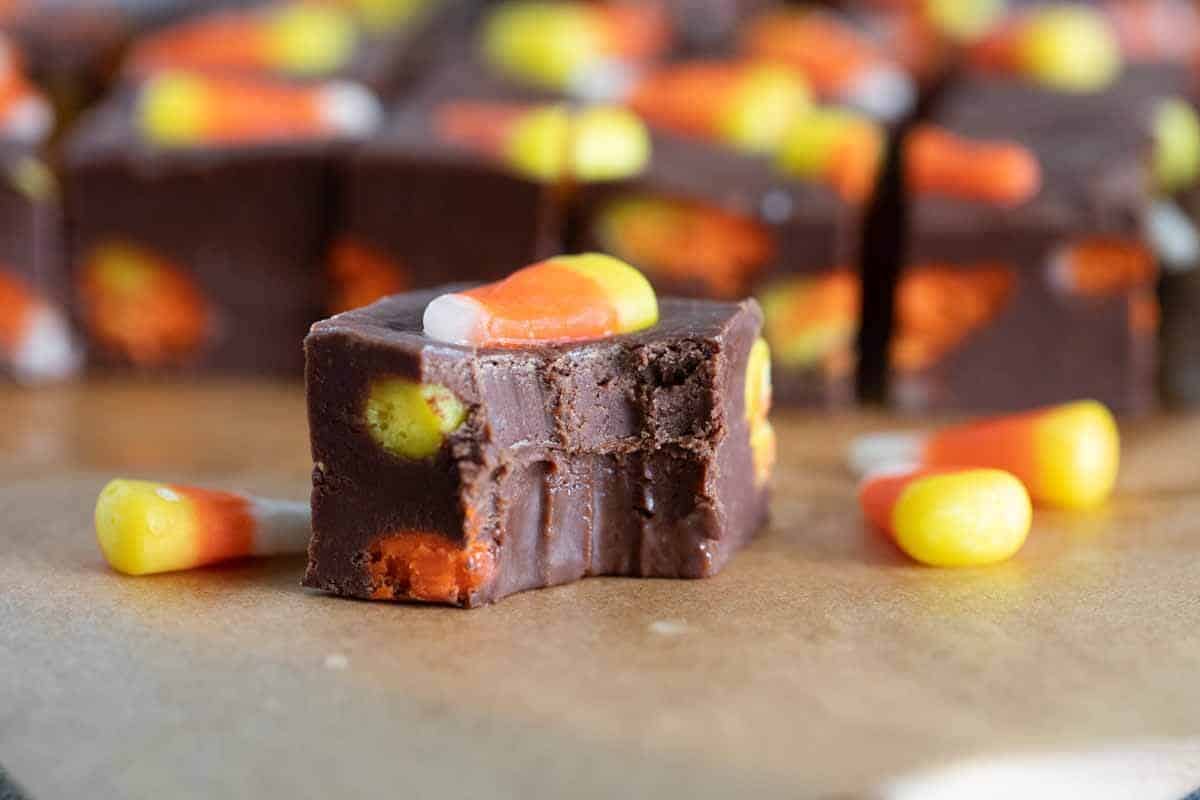 Piece of candy corn fudge with a bite taken from it.