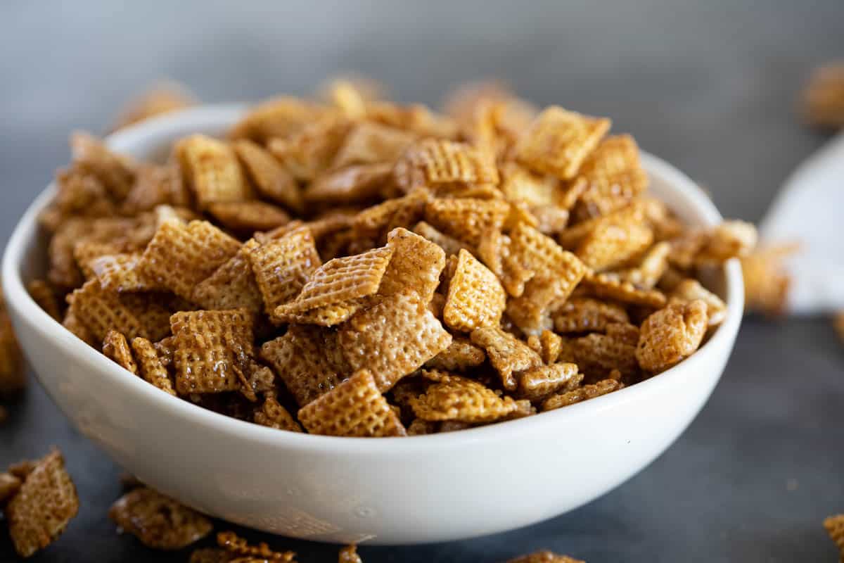 White bowl filled with cinnamon caramel snack mix.