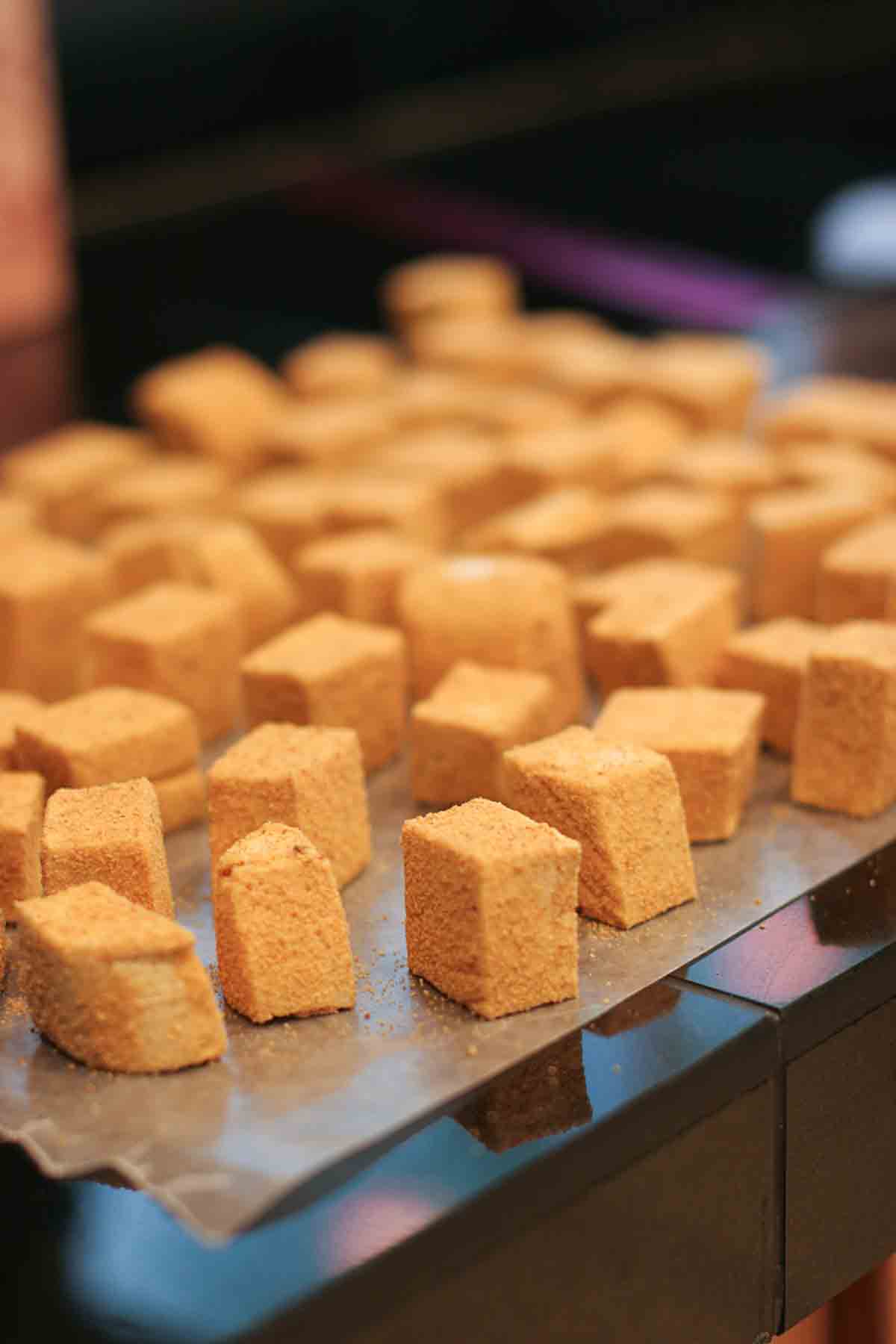 Fresh pumpkin spice marshmallows on a piece of wax paper.