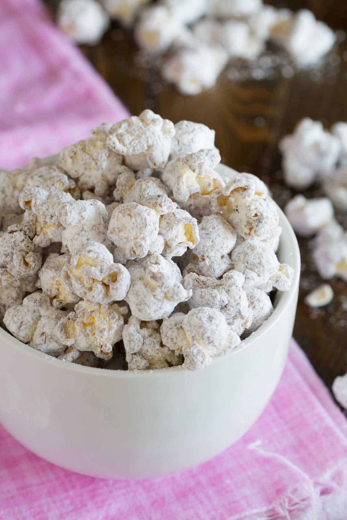 White bowl filled with muddy buddy popcorn.