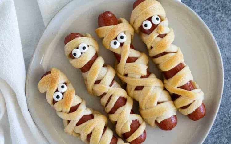 Four Mummy Hot Dogs on a plate.