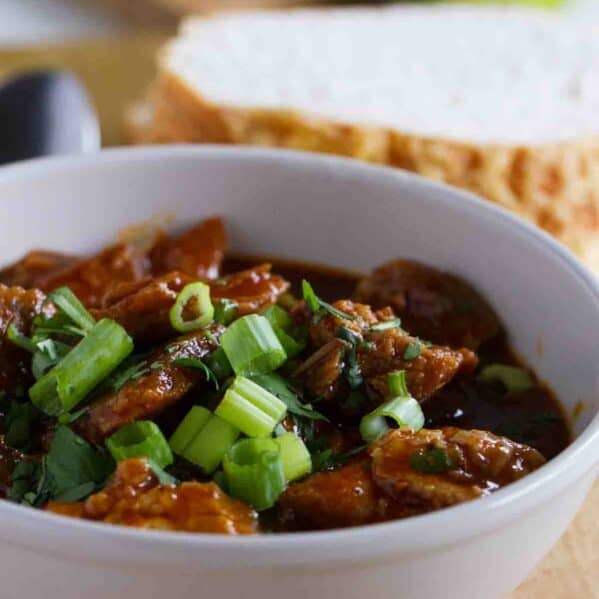 Chili with chunks of pork and a red sauce.