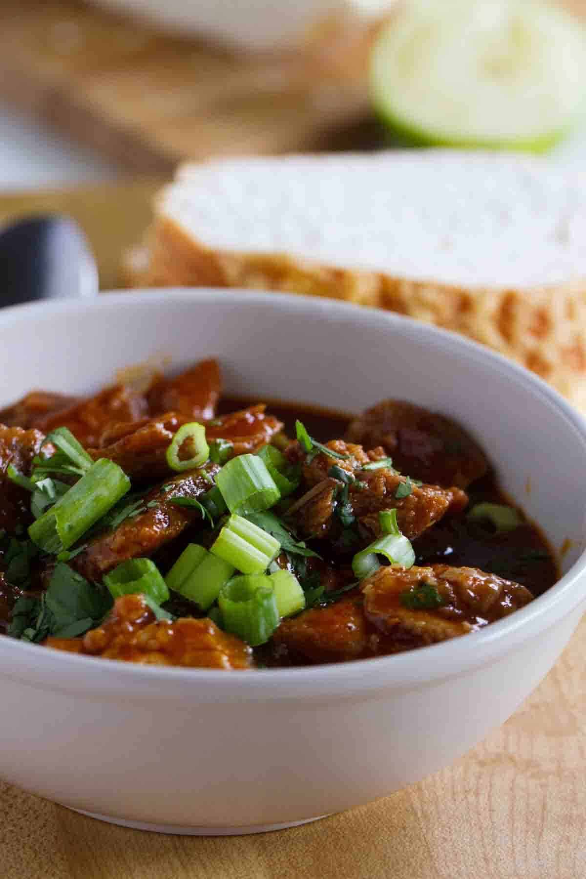 Chili with chunks of pork and a red sauce.