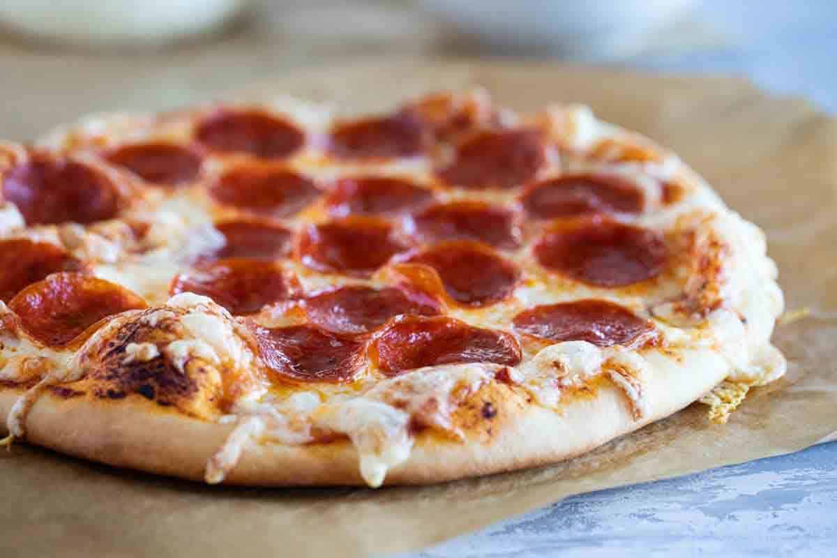 Baked pepperoni pizza on a piece of parchment paper