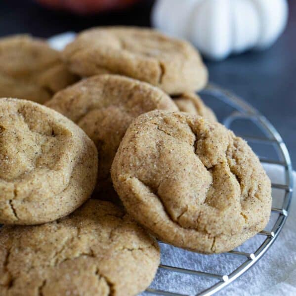 Pumpkin Snickerdoodles stacked on a cooling rack.
