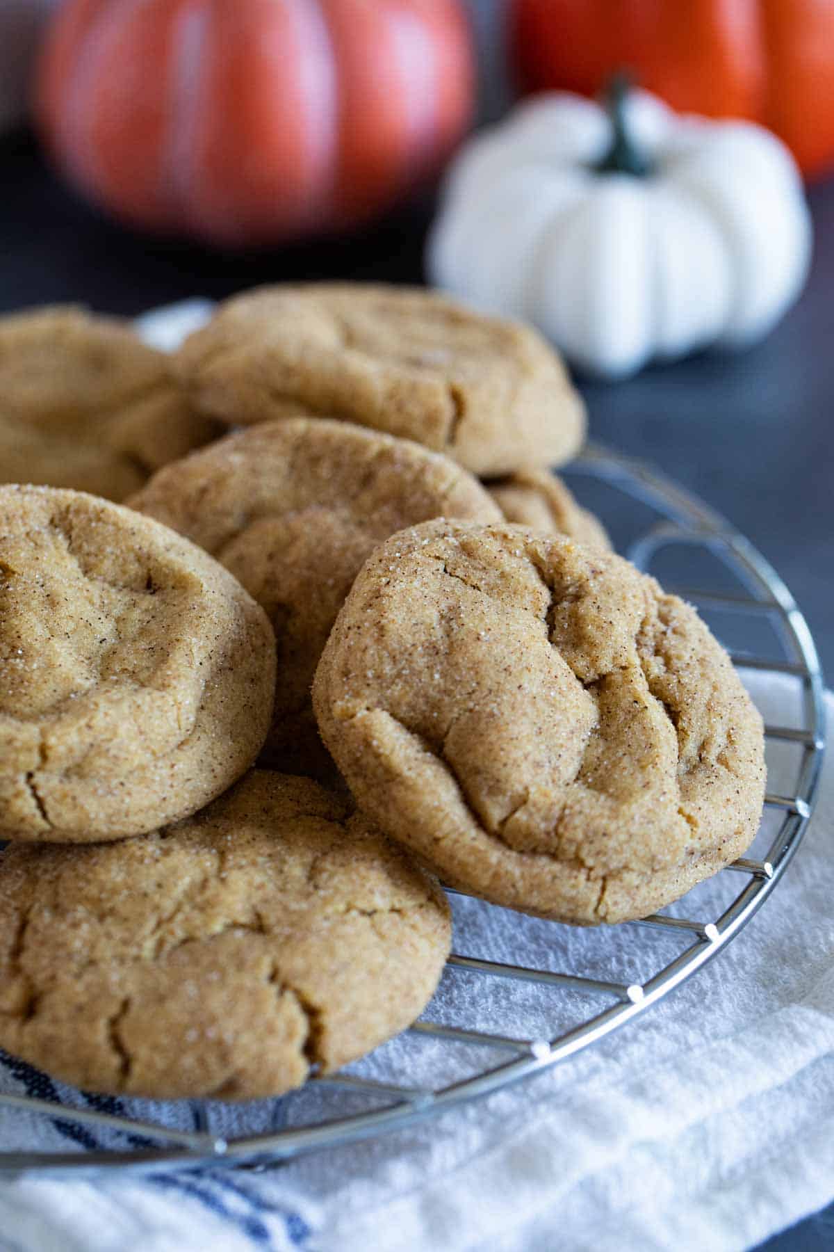 Pumpkin Snickerdoodles stacked on a cooling rack.