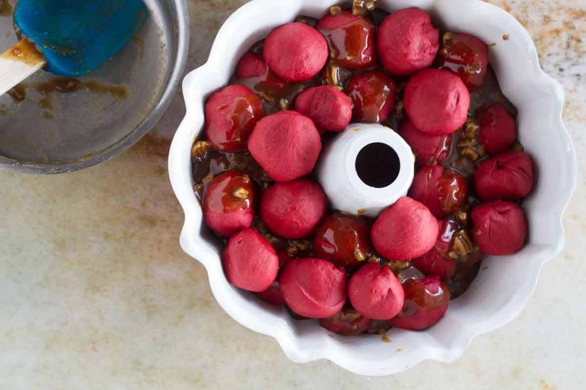 Layering ingredients in a bundt pan for pull apart bread.