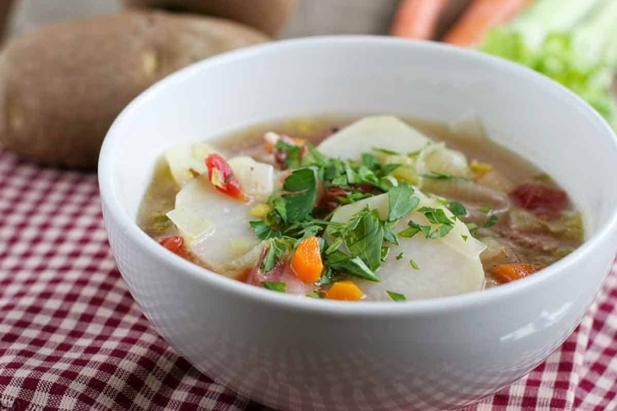 Bowl of Tomato and Potato Soup with Bacon topped with parsley.