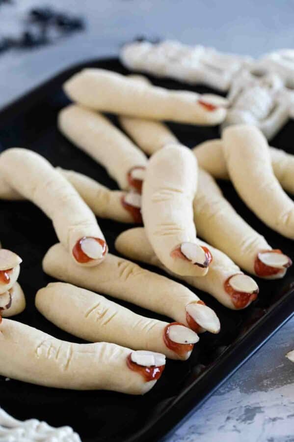 Witch Fingers cookies on a black tray.