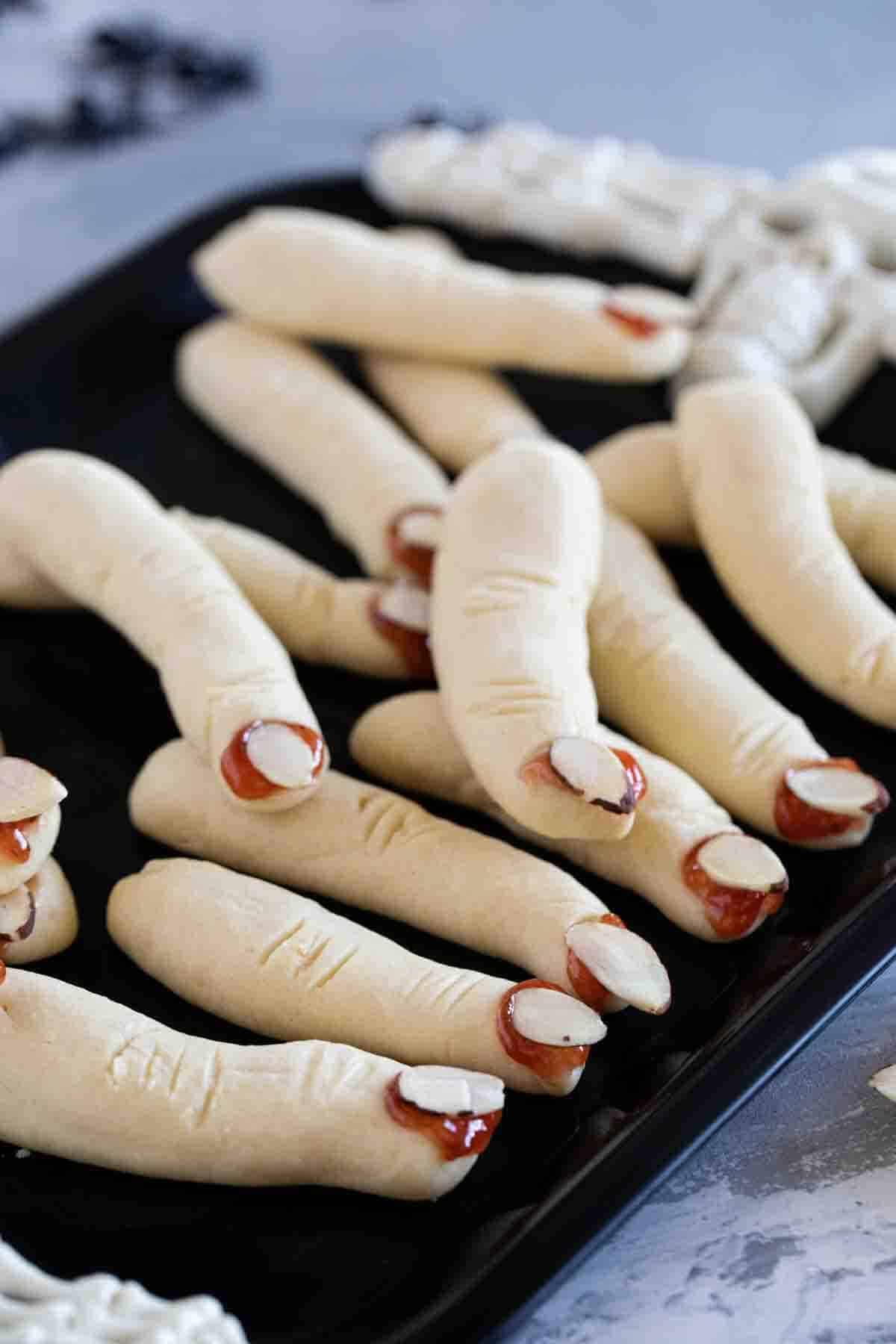 Witch Fingers cookies on a black tray.