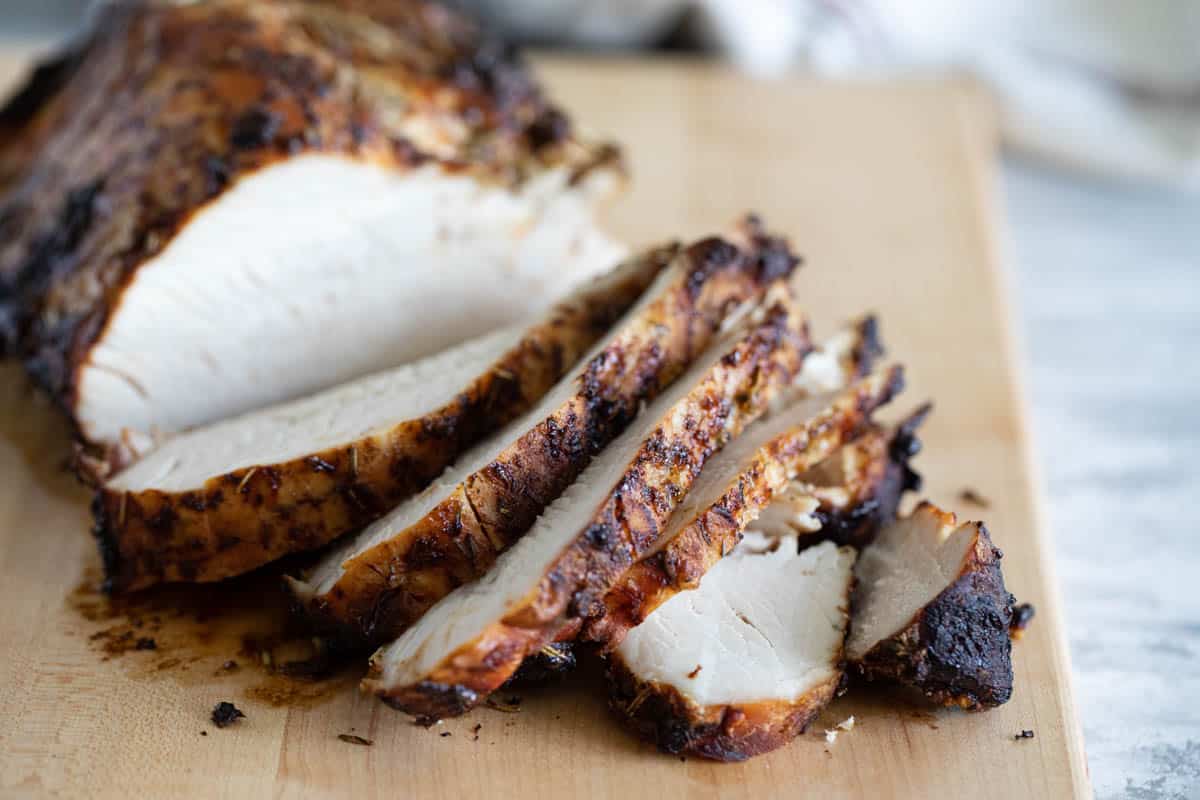Turkey breast on a cutting board being sliced.