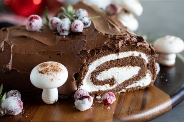 Yule log cake with meringue mushrooms and candied cranberries.