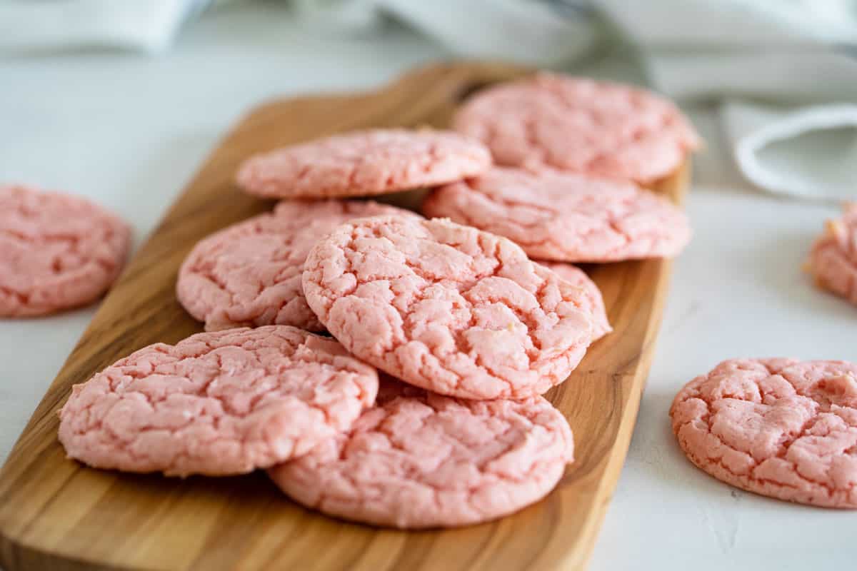Strawberry cake mix cookies on a cutting board.