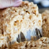 Pulling out a caramel rice krispie showing the gooey marshmallow.