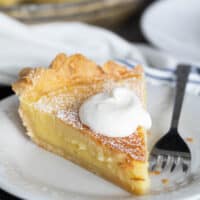 Slice of Chess Pie topped with whipped cream.