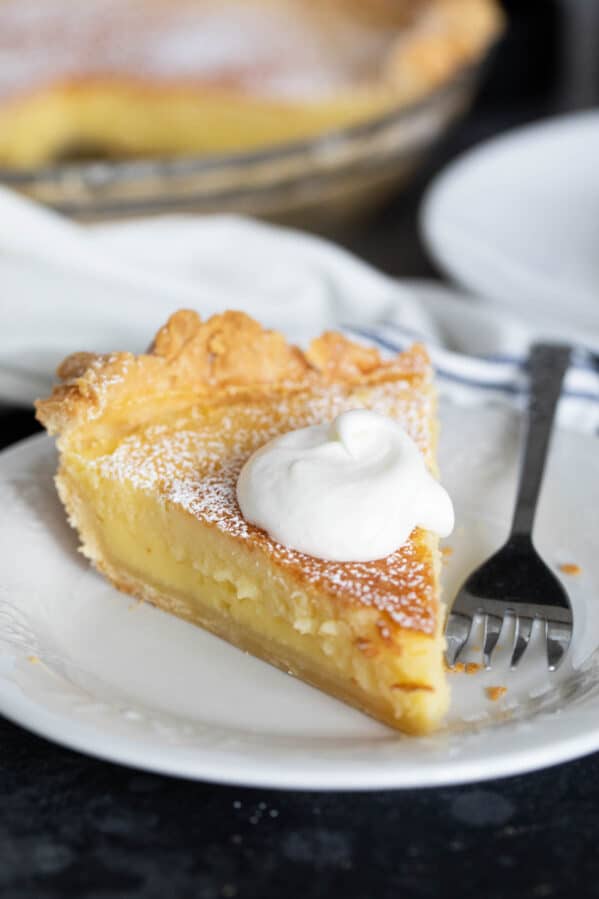 Slice of Chess Pie topped with whipped cream.