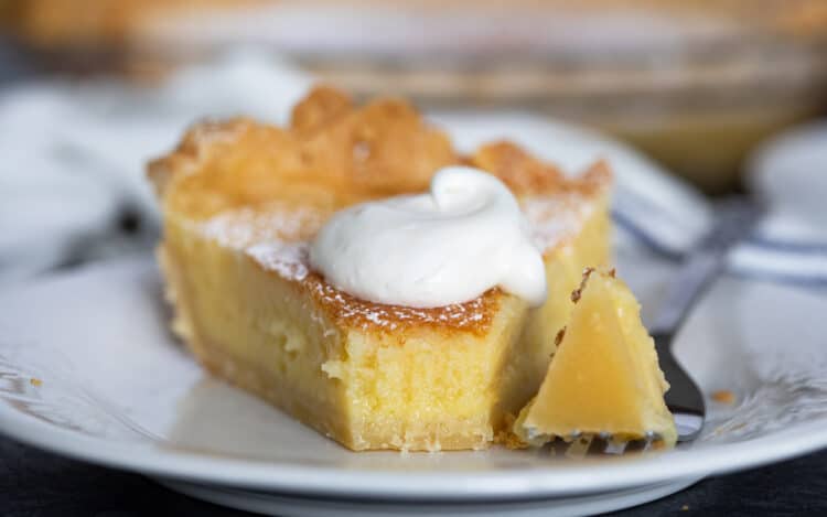 Slice of chess pie with a fork full taken from it.