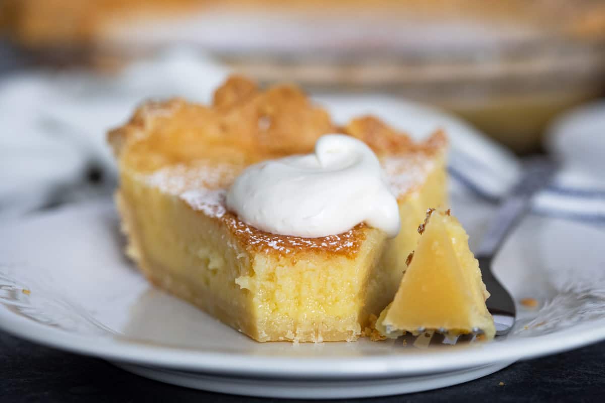 Slice of chess pie with a fork full taken from it.