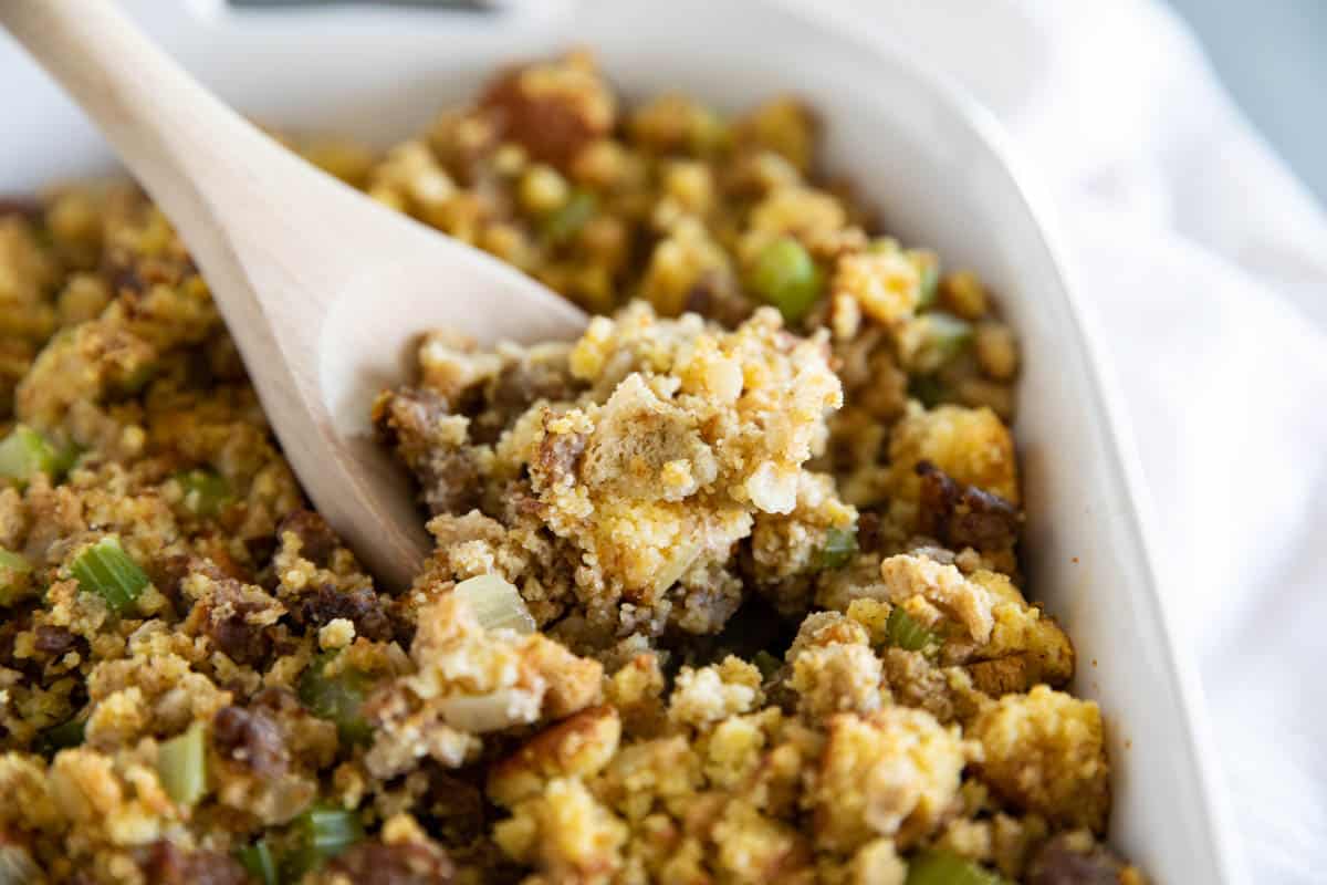 Serving spoon filled with cornbread stuffing.