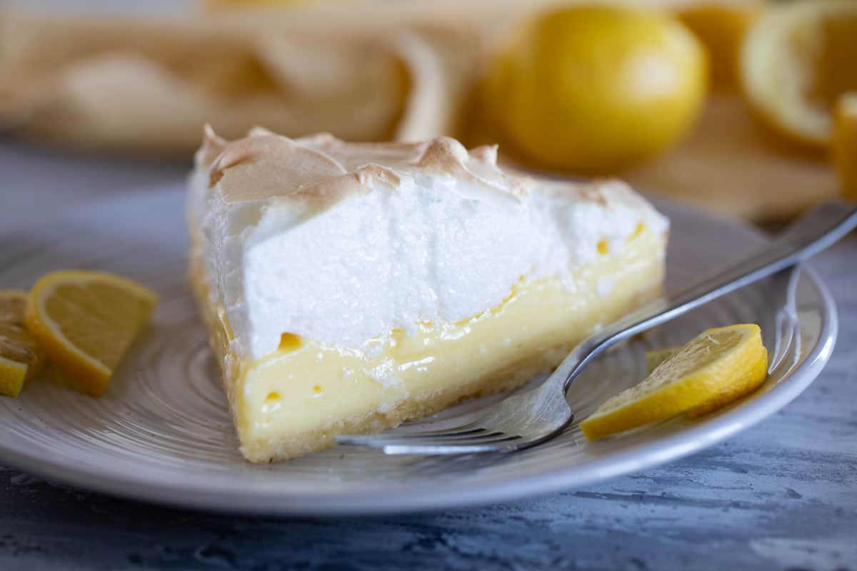 Slice of French Lemon Cream Tart with Meringue on a plate.