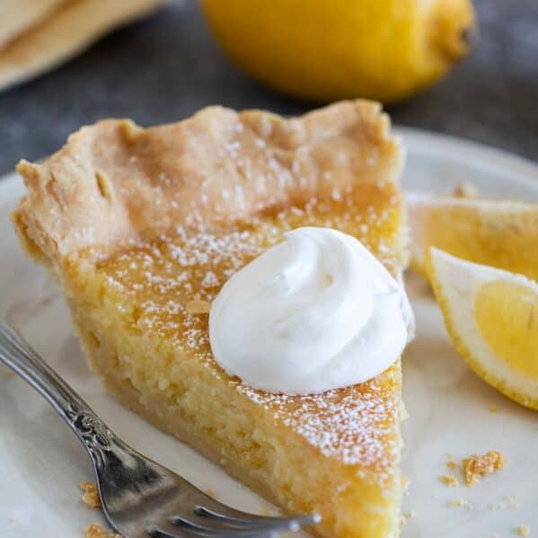 Slice of lemon chess pie topped with whipped cream.
