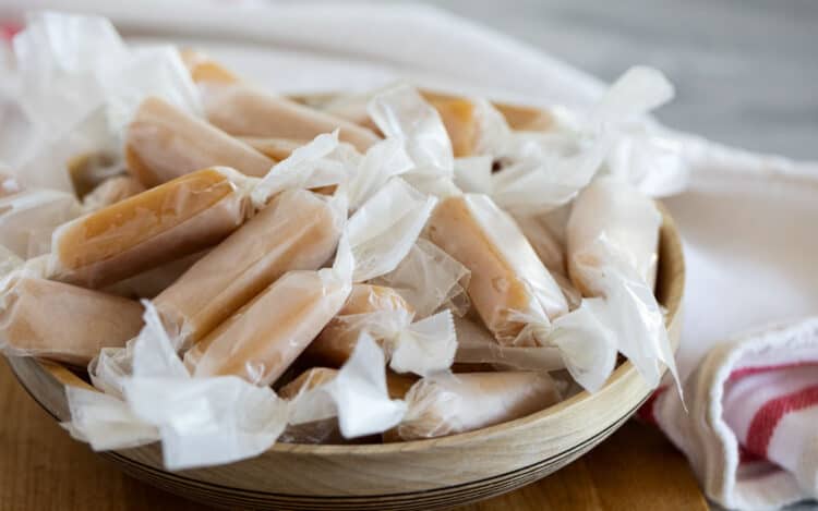 Wrapped caramel candy in a wooden bowl.