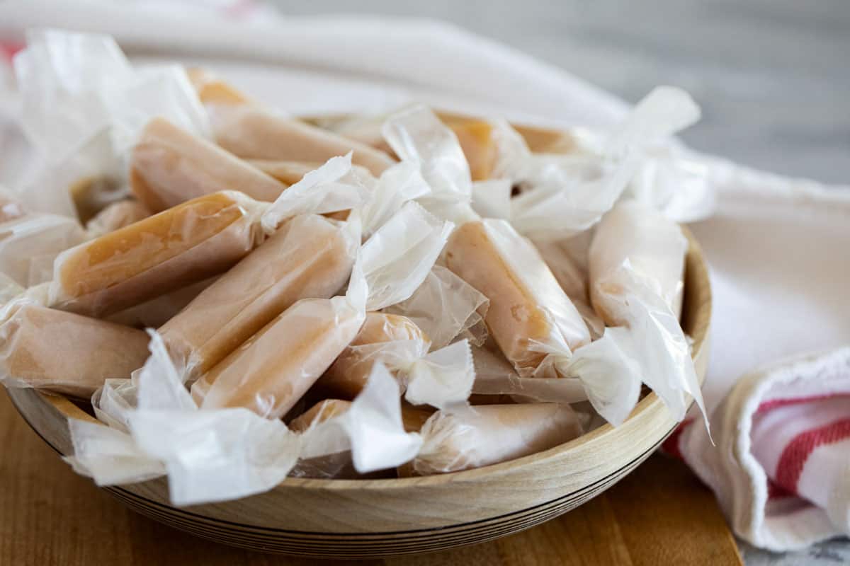 Wrapped caramel candy in a wooden bowl.