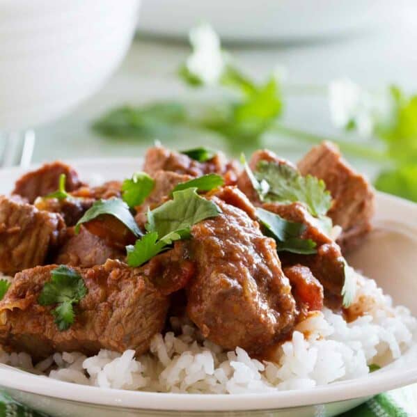 Slow cooker beef with salsa over rice and topped with cilantro.