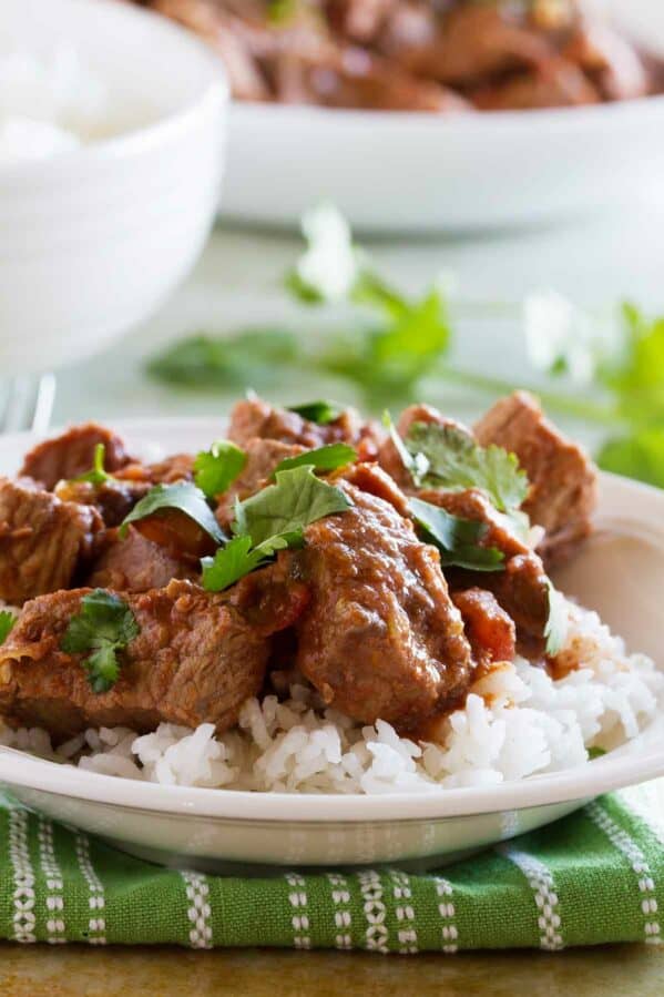 Slow cooker beef with salsa over rice and topped with cilantro.