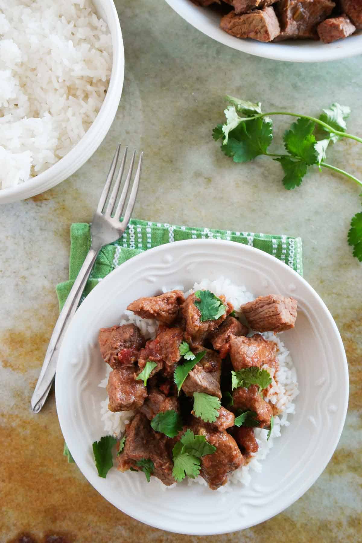 Plate with rice topped with slow cooker beef with salsa.